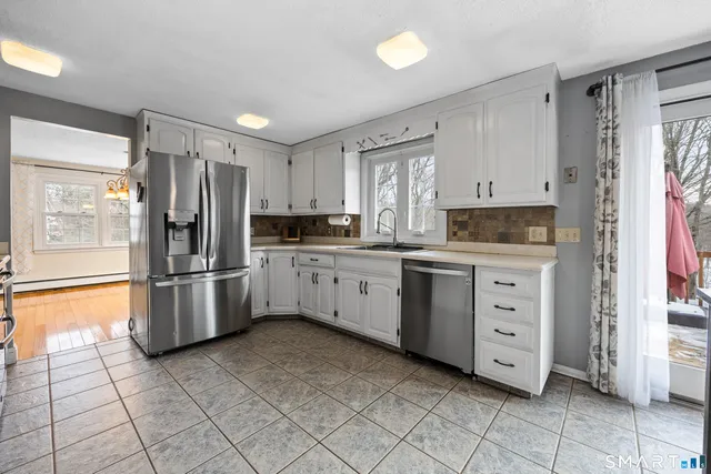 a kitchen with stainless steel appliances a refrigerator sink and cabinets