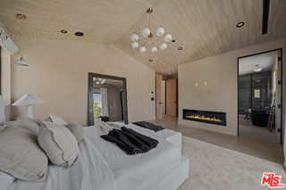 11317 Valley Spring Lane Studio City, CA 91602 - Photo 32 of 44 a bedroom with a bed and a chandelier