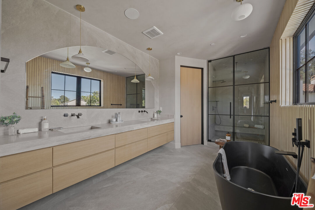 11317 Valley Spring Lane Studio City, CA 91602 - Photo 33 of 44 a large bathroom with a tub sink and mirror