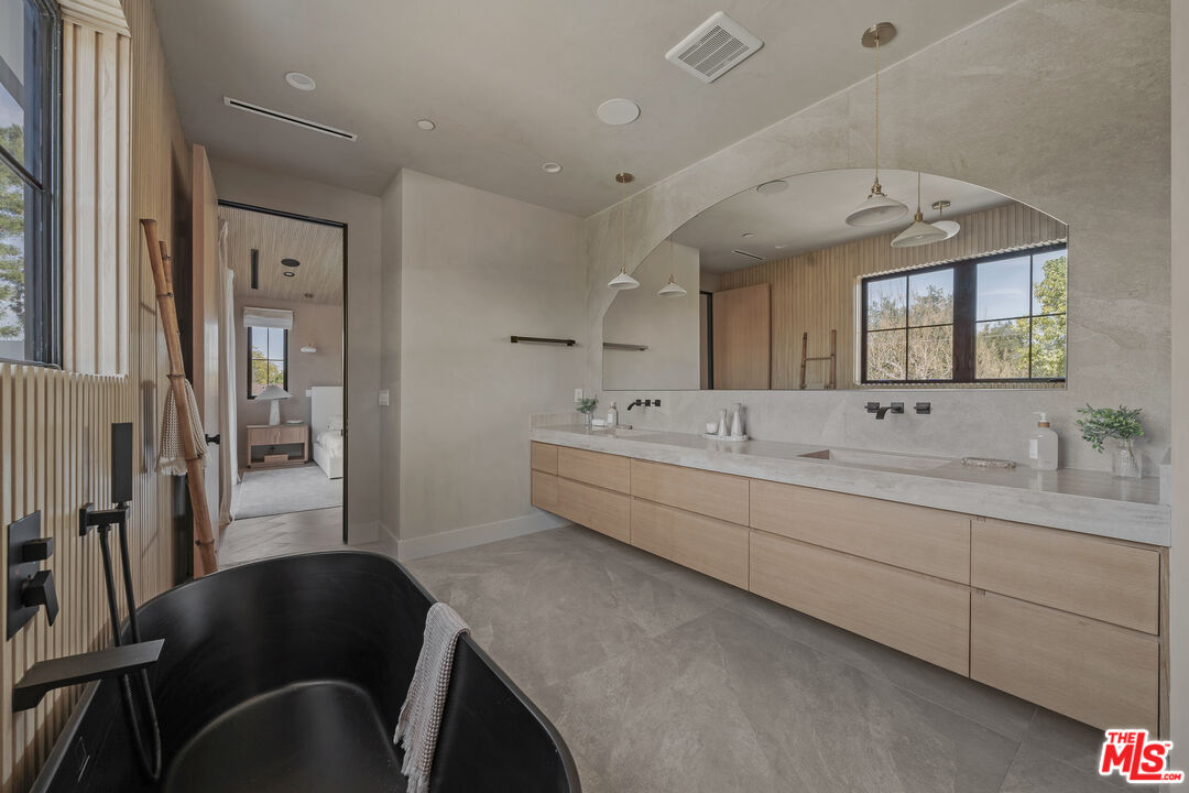 11317 Valley Spring Lane Studio City, CA 91602 - Photo 34 of 44 a spacious bathroom with a double vanity sink and a mirror