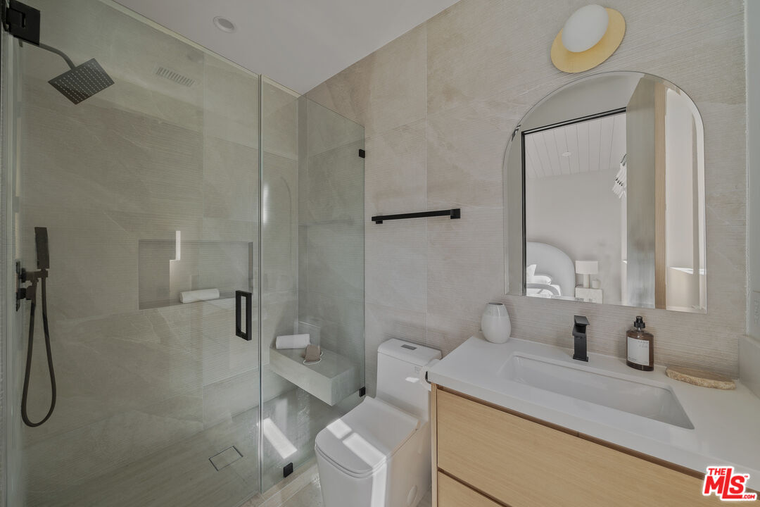 11317 Valley Spring Lane Studio City, CA 91602 - Photo 41 of 44 a bathroom with a granite countertop sink toilet and shower