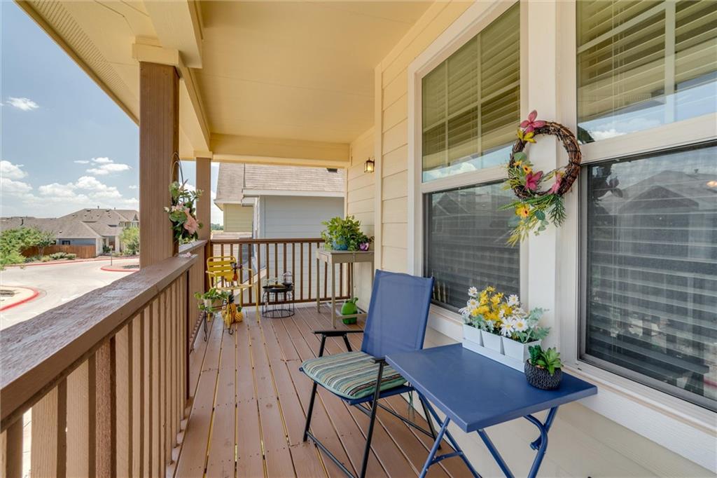 4606 Kind Way, Unit 285 Austin, TX 78725 - Photo 12 of 14 Inviting covered porch with a wooden floor, railing, and exterior wall, offering a pleasant outdoor space