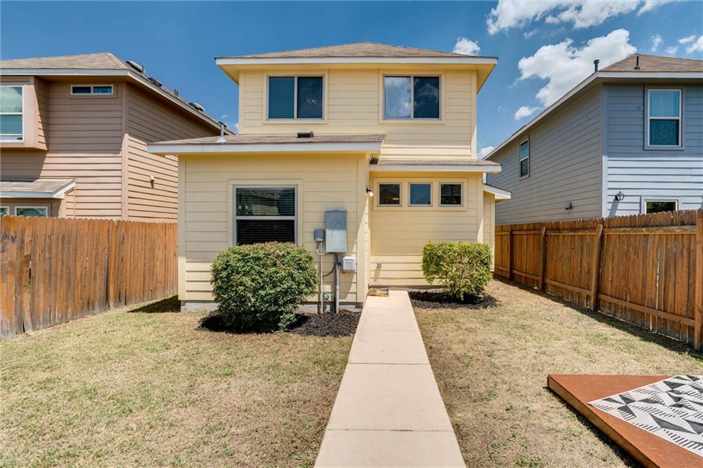 4606 Kind Way, Unit 285 Austin, TX 78725 - Photo 14 of 14 The property features a two-story exterior with yellow siding and a fenced yard