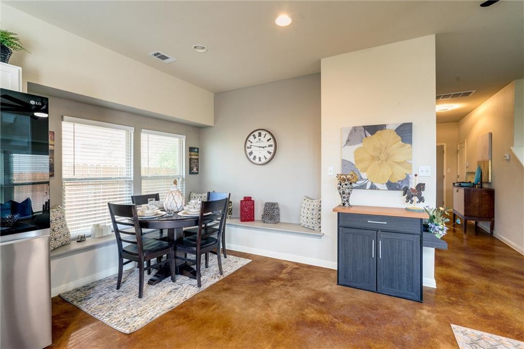4606 Kind Way, Unit 285 Austin, TX 78725 - Photo 4 of 14 Dining area featuring rich brown flooring, a round dining table with four chairs, and a built-in window bench
