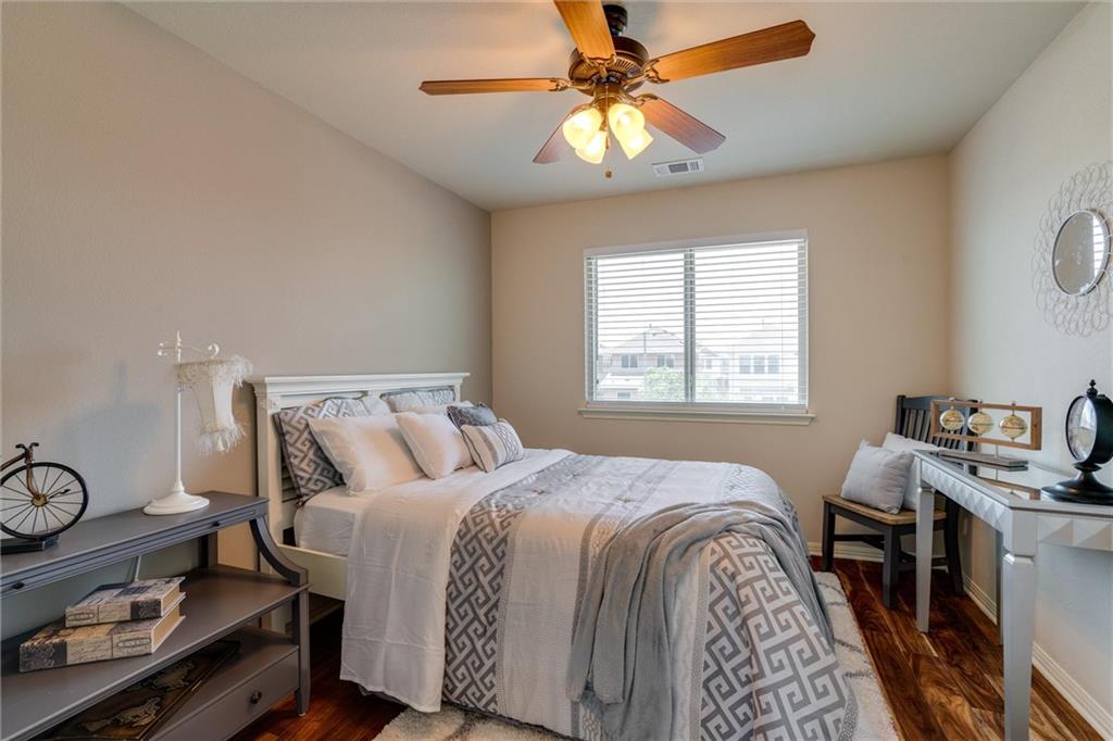 4606 Kind Way, Unit 285 Austin, TX 78725 - Photo 8 of 14 This room features hardwood flooring, a ceiling fan with integrated lighting, and a window with blinds