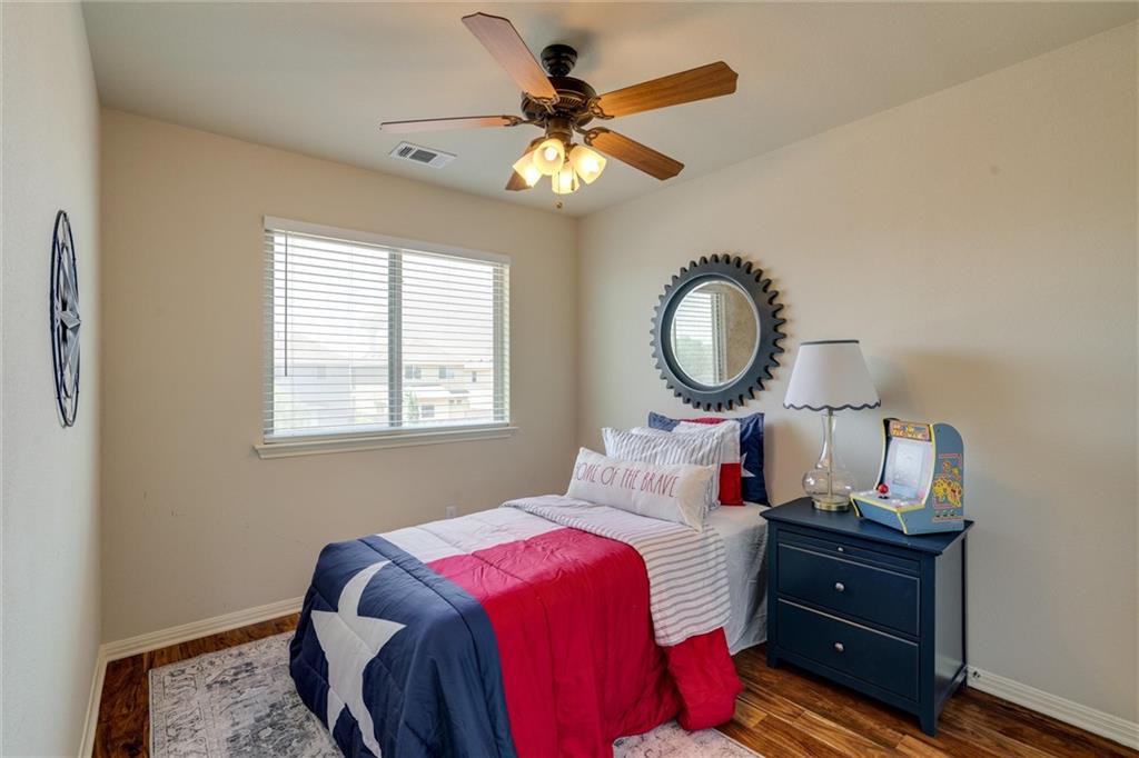 4606 Kind Way, Unit 285 Austin, TX 78725 - Photo 10 of 14 This room features hardwood flooring, a window with blinds, and a ceiling fan with integrated lighting