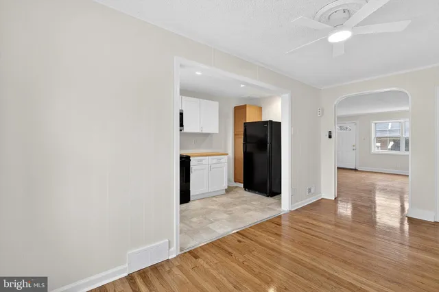a view of a kitchen with wooden floor and a refrigerator