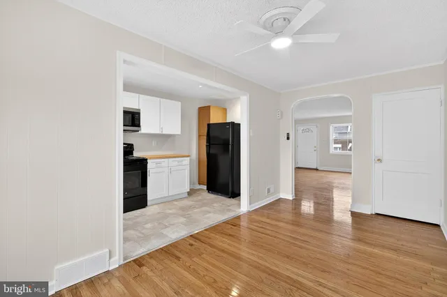 a view of a kitchen with wooden floor and a refrigerator