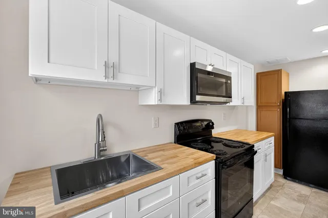 a kitchen with granite countertop white cabinets and stainless steel appliances