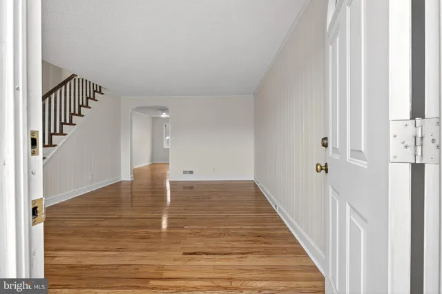 a view of a hallway with wooden floor and staircase