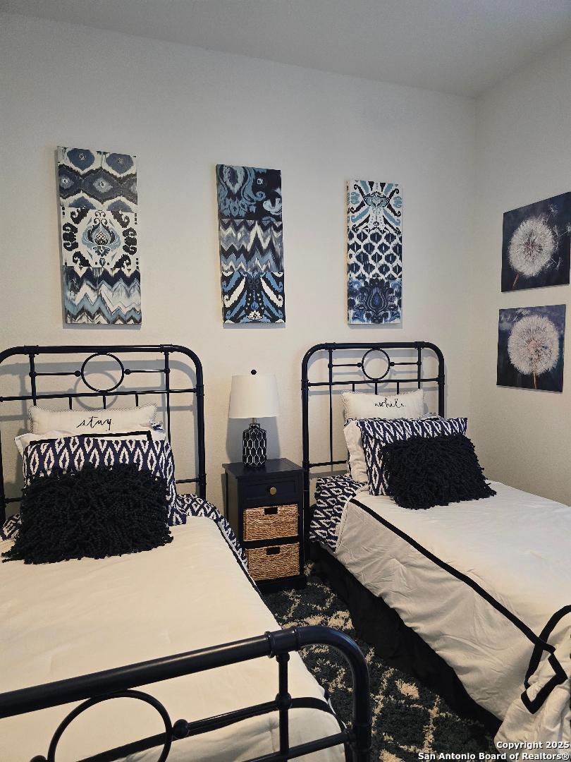 451 Legion Loop Kingsland, TX 78639 - Photo 12 of 23 a bedroom with a bed and wall painting