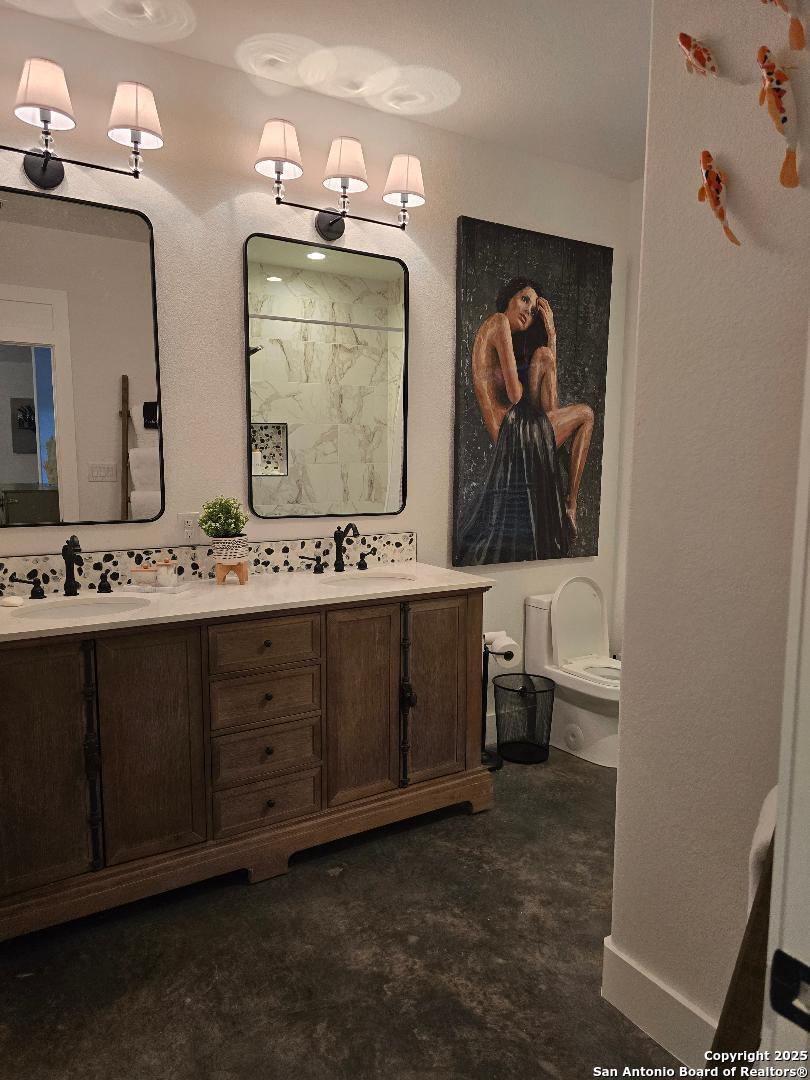 451 Legion Loop Kingsland, TX 78639 - Photo 16 of 23 a bathroom with double vanity sink and a mirror