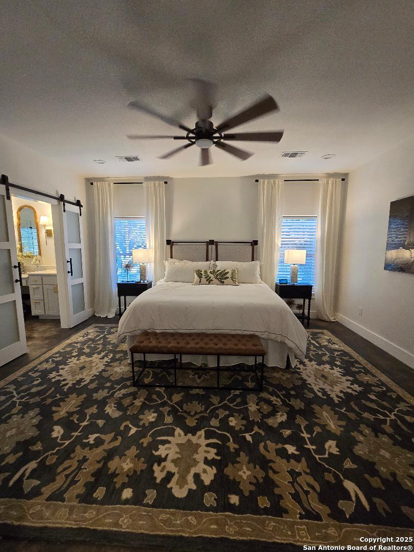 451 Legion Loop Kingsland, TX 78639 - Photo 5 of 23 a spacious bedroom with a bed a mirror and windows