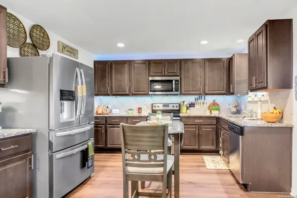 a kitchen with stainless steel appliances granite countertop a refrigerator stove microwave and sink