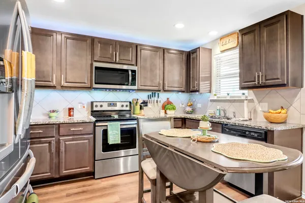 a kitchen with a stove a sink a microwave and wooden cabinets