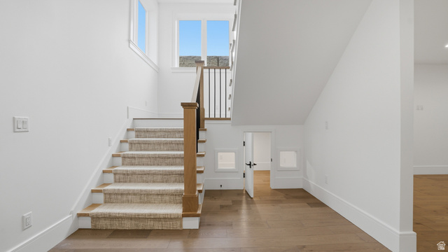 1682 North 1950 W Street, Unit 9 Provo, UT 84604 - Photo 41 of 84 Staircase featuring wood-finish treads and a neutral-toned runner, complemented by a wood-finish newel post and black metal balusters