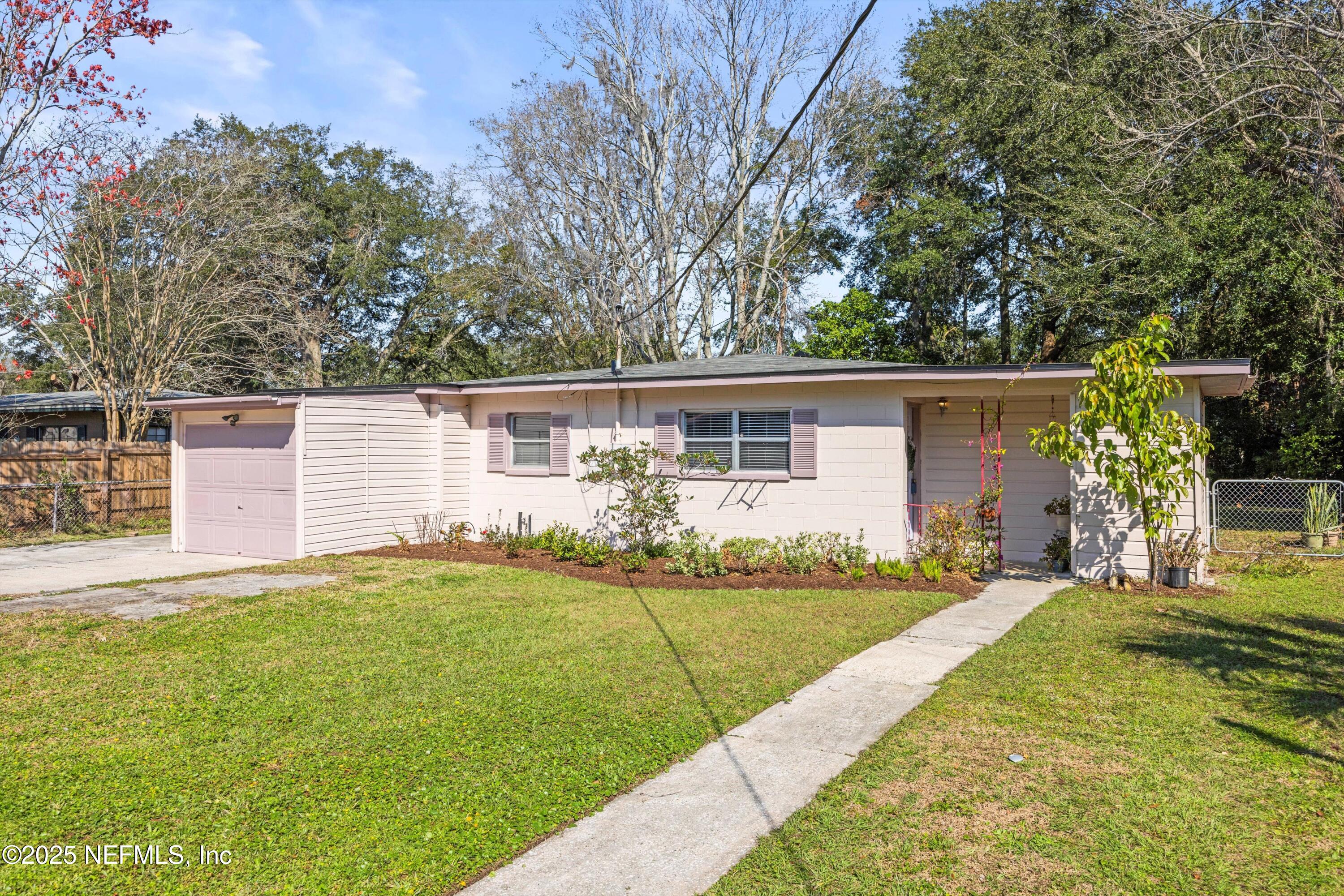 a view of a house with a yard and a tree