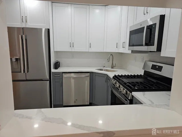 a kitchen with stainless steel appliances a refrigerator stove and microwave