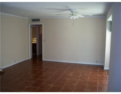 en empty room with wooden floor and fan
