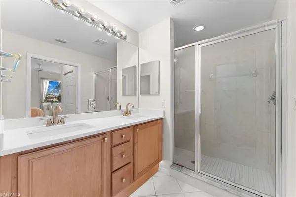 a bathroom with a double vanity sink mirror and shower