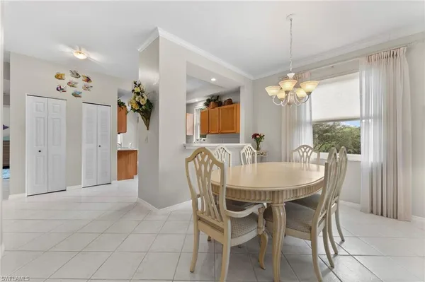 a dining room with furniture a chandelier and window