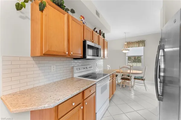 a kitchen with stainless steel appliances granite countertop a sink stove and microwave