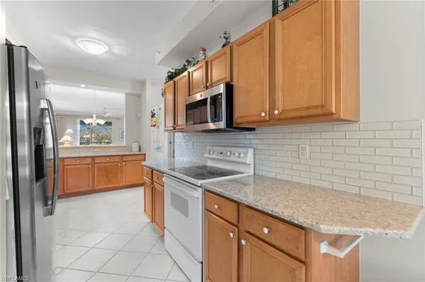 a kitchen with stainless steel appliances granite countertop a sink a stove a microwave a counter top space and cabinets