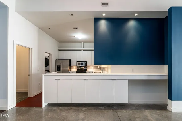 a large white kitchen with a large window