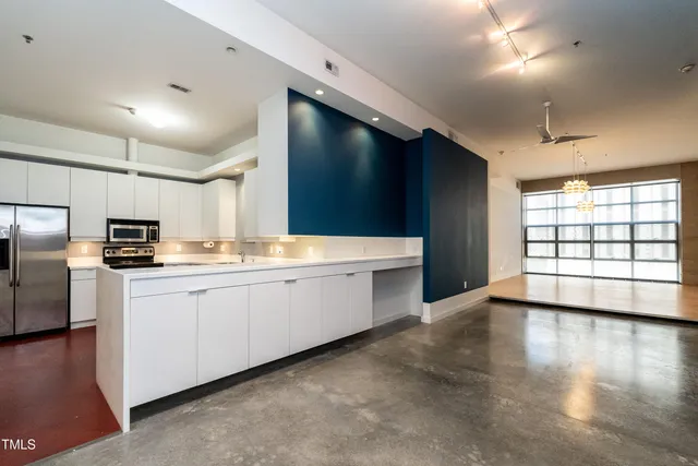 a kitchen with a refrigerator a sink a stove and cabinets