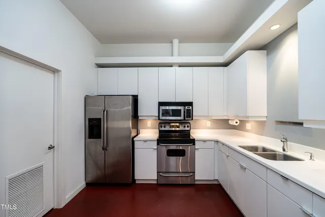 a kitchen with a sink a stove top oven and refrigerator