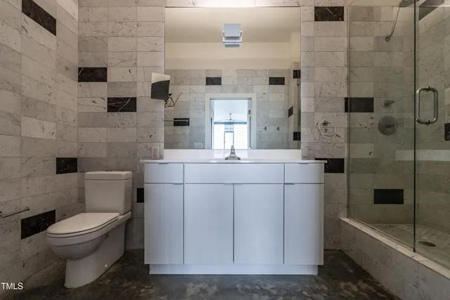 a bathroom with a sink shower and a mirror