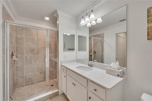 a bathroom with a double vanity sink mirror and shower
