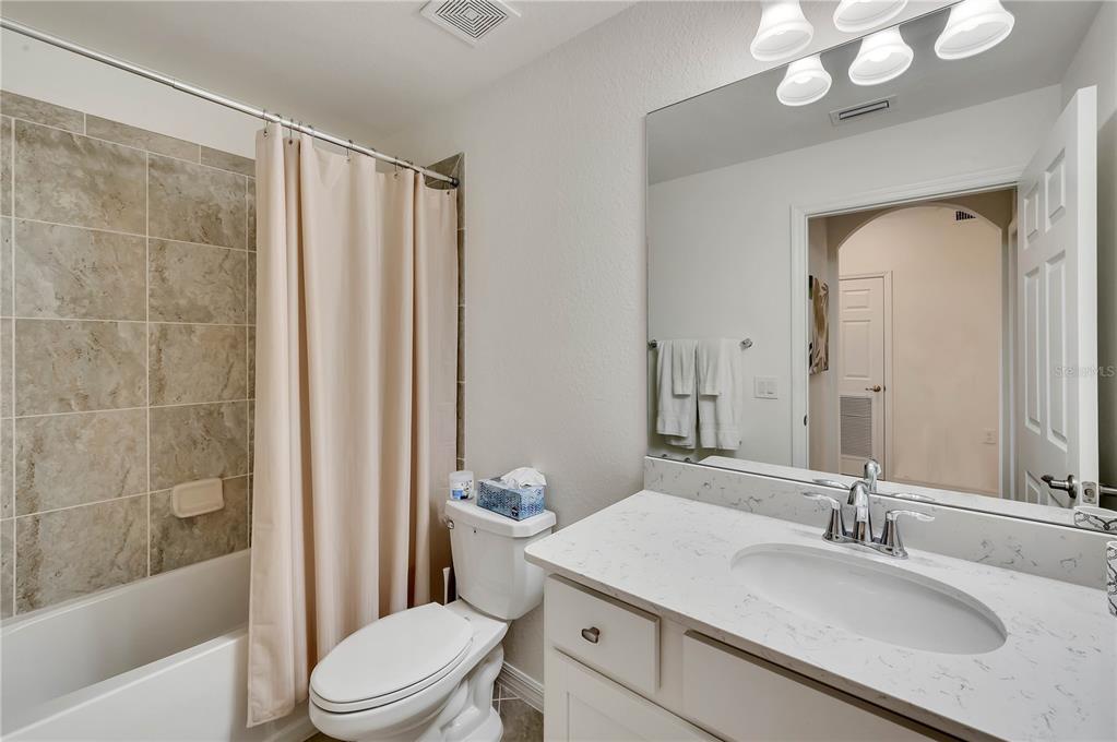 17510 Gawthrop Drive, Unit 203 Lakewood Ranch, FL 34211 - Photo 22 of 54 a bathroom with a granite countertop sink toilet a mirror a vanity and bathtub