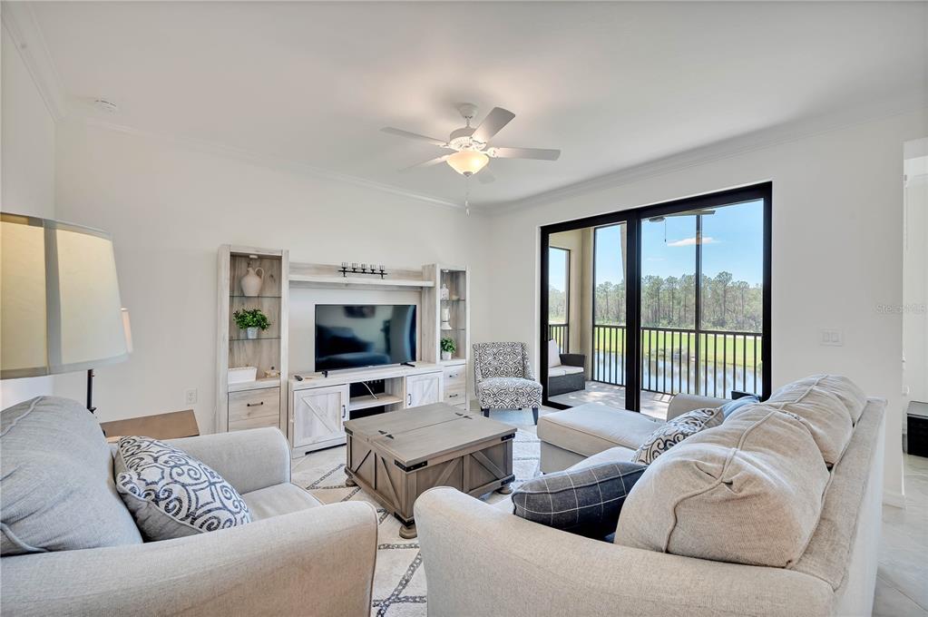 17510 Gawthrop Drive, Unit 203 Lakewood Ranch, FL 34211 - Photo 6 of 54 a living room with furniture and a flat screen tv