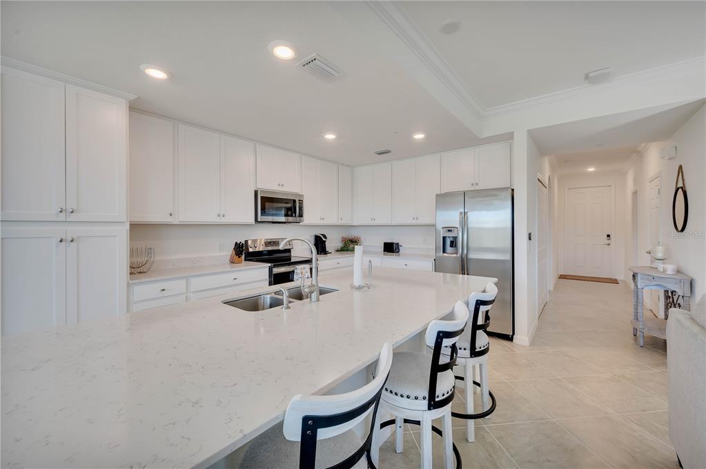 17510 Gawthrop Drive, Unit 203 Lakewood Ranch, FL 34211 - Photo 8 of 54 a kitchen with stainless steel appliances a refrigerator a stove a sink a dining table and chairs