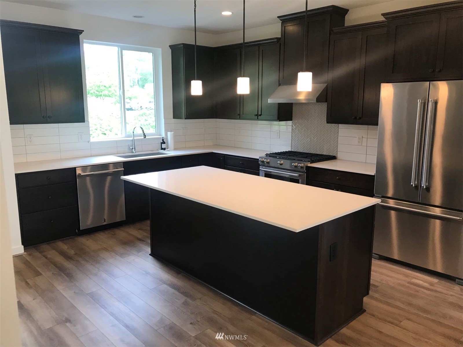 2405 217th Street Southeast, Unit B Bothell, WA 98021 - Photo 14 of 27 a kitchen with stainless steel appliances kitchen island a sink dishwasher a refrigerator and wooden floor
