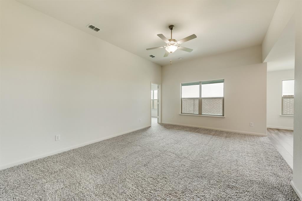 9516 Teton Vista Drive Fort Worth, TX 76140 - Photo 2 of 11 an empty room with windows and fan chandelier fan