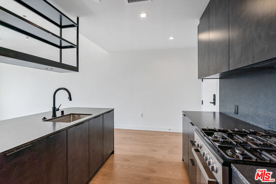 10700 Tabor Street, Unit 524 Los Angeles, CA 90034 - Photo 4 of 12 a kitchen with granite countertop a stove and a sink