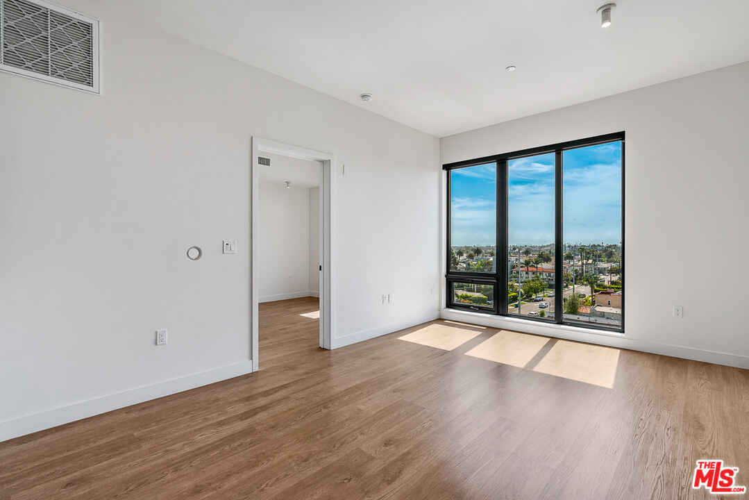10700 Tabor Street, Unit 524 Los Angeles, CA 90034 - Photo 5 of 12 an empty room with wooden floor and windows