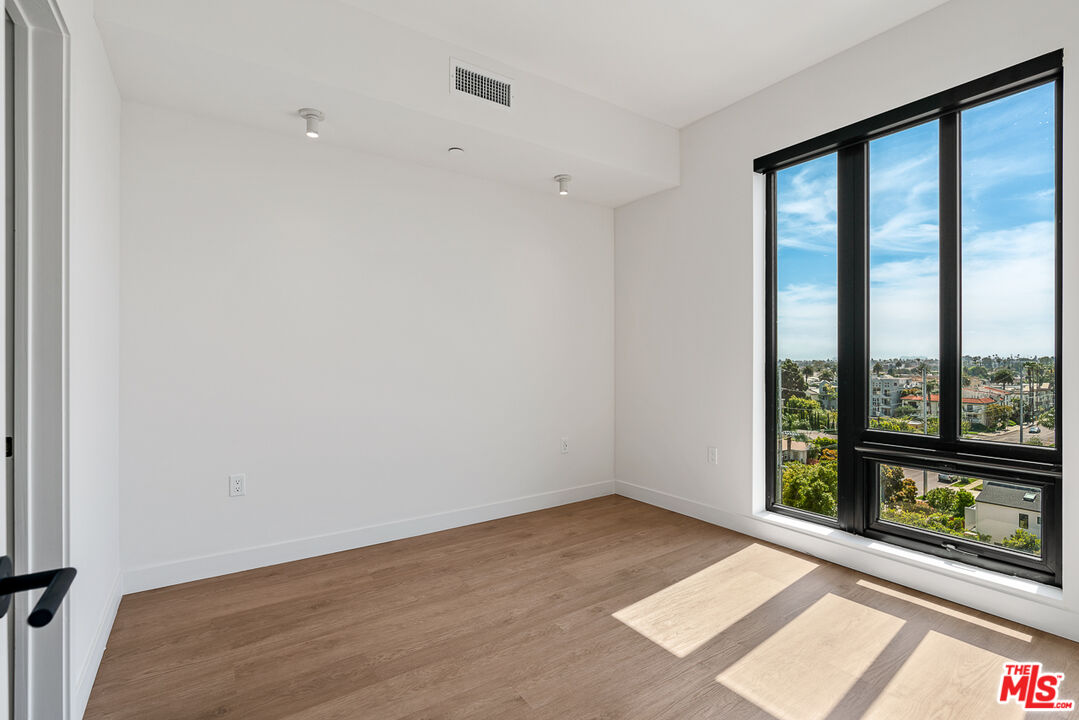 10700 Tabor Street, Unit 524 Los Angeles, CA 90034 - Photo 7 of 12 an empty room with wooden floor and windows