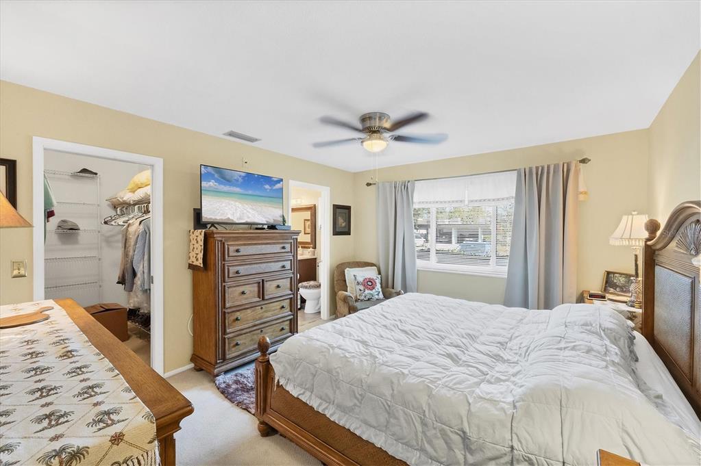 3990 Overlook Bend Terrace, Unit 19 Sarasota, FL 34232 - Photo 14 of 29 a bedroom with a large bed a flat tv screen and a dresser