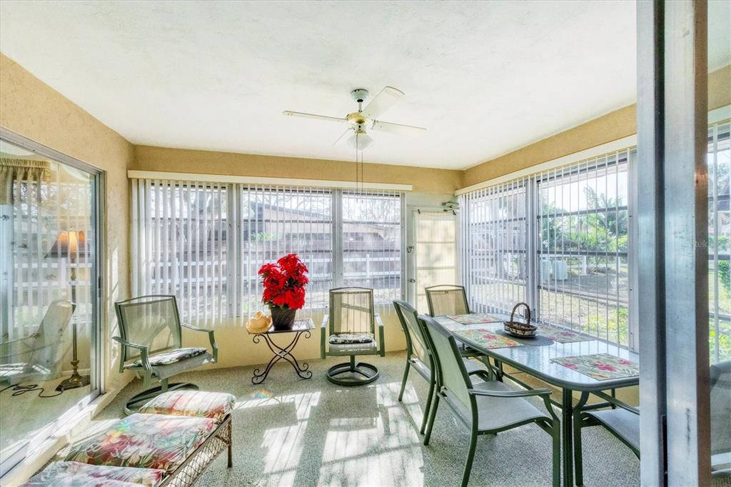 3990 Overlook Bend Terrace, Unit 19 Sarasota, FL 34232 - Photo 18 of 29 a view of a dining room with furniture large windows and wooden floor