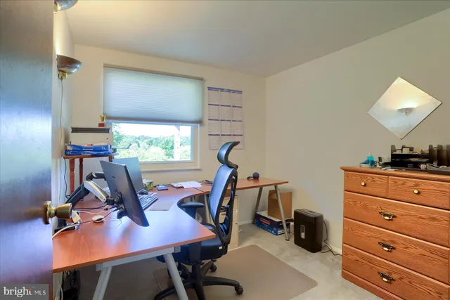 a view of a workspace with furniture and a window
