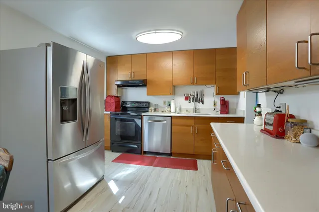 a kitchen with stainless steel appliances granite countertop a refrigerator sink and stove