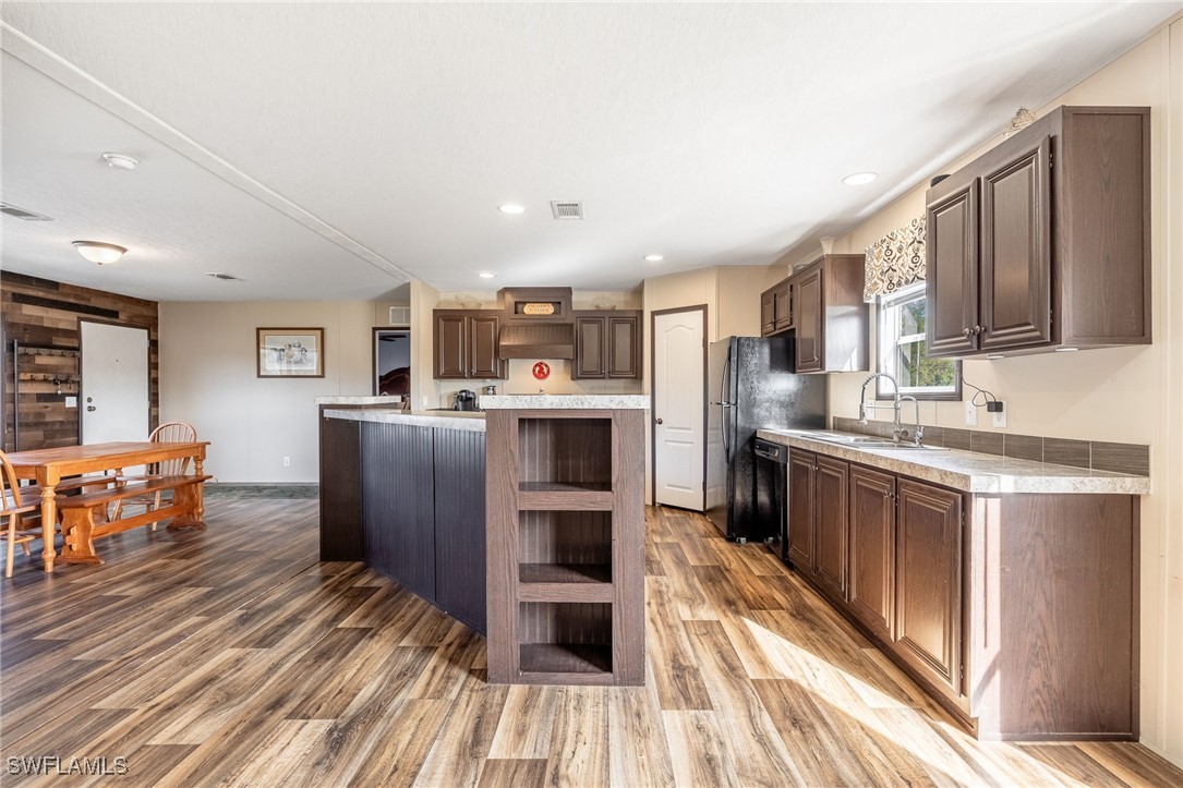 10491 Deal Road North Fort Myers, FL 33917 - Photo 12 of 48 a kitchen with stainless steel appliances granite countertop a refrigerator oven a sink dishwasher and white cabinets with wooden floor