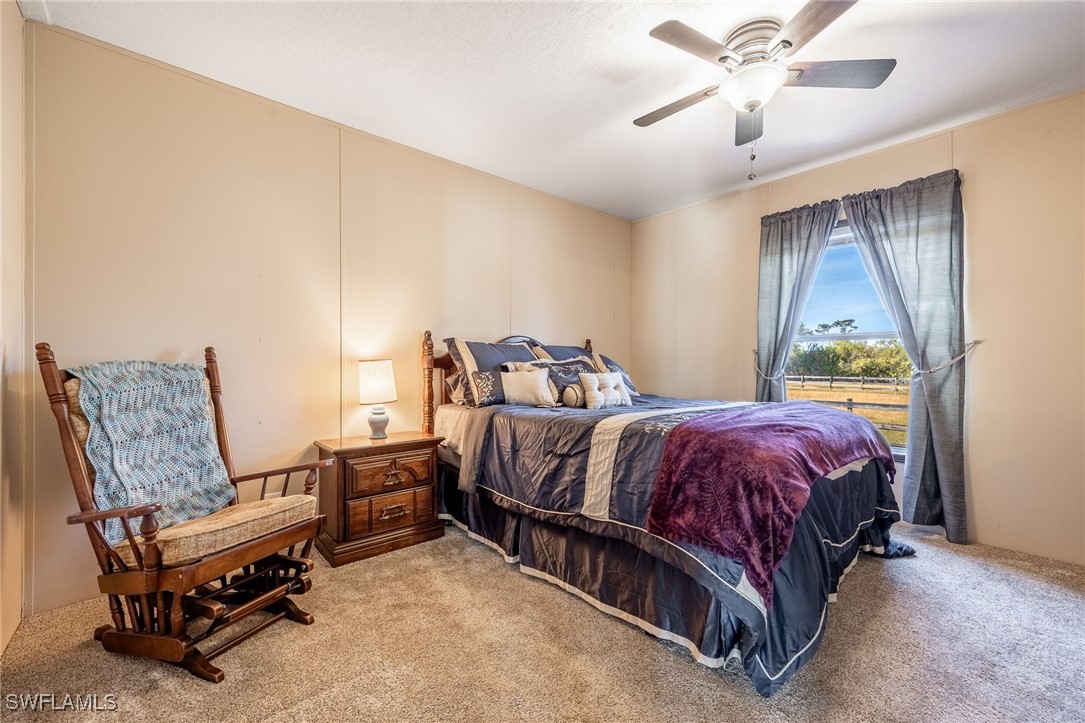 10491 Deal Road North Fort Myers, FL 33917 - Photo 25 of 48 a spacious bedroom with a bed and a chandelier