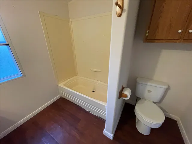 a bathroom with a toilet and a shower