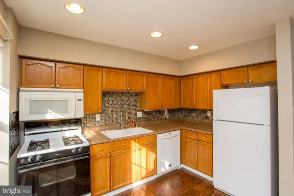 a kitchen with a refrigerator and a stove top oven
