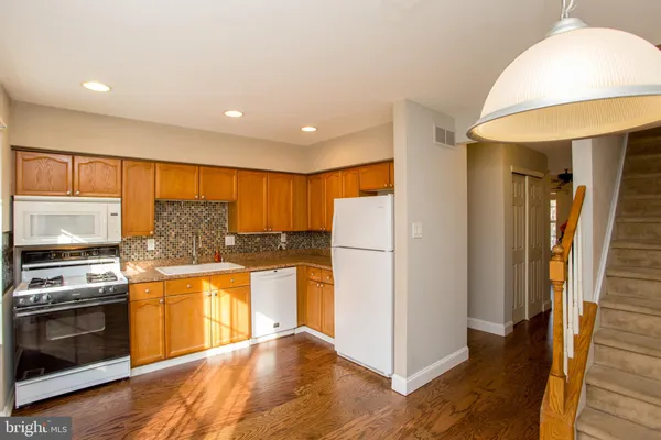 a kitchen with stainless steel appliances granite countertop a refrigerator a stove and a sink