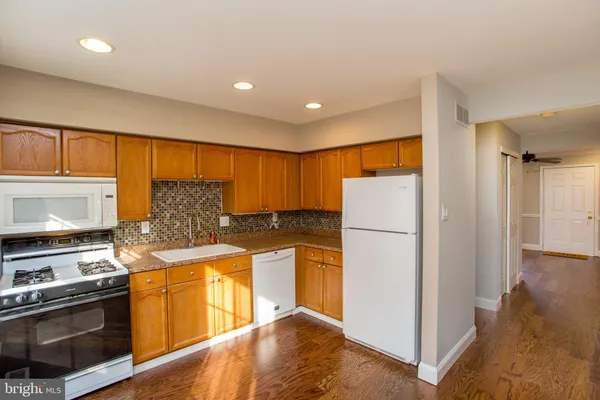 a kitchen with stainless steel appliances granite countertop a refrigerator a stove a sink and a microwave